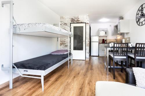 达马利百合APPART PREMIUM DU LYS Balcon amenage Parking gratuit的一间带双层床的卧室和一间餐厅