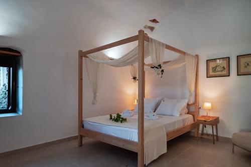 干尼亚Marthas DeLight Rooms的卧室配有带白色床单的天蓬床