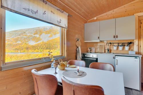 KjøllefjordDavvi Siida - Reindeer Design Lodge的厨房配有桌椅和窗户。