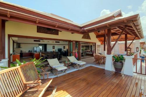 芭东海滩Patong Seaview Luxury Villa Penda的木制甲板上配有桌椅