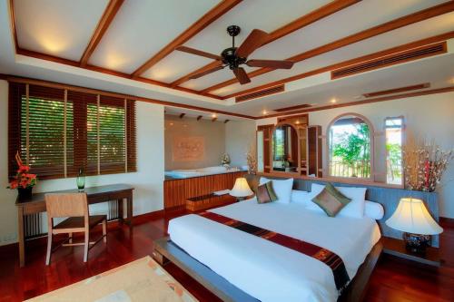 芭东海滩Patong Seaview Luxury Villa Penda的卧室配有一张白色大床和一张书桌
