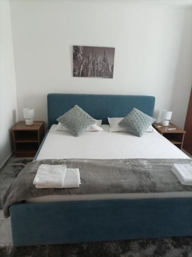 奥西耶克ARENA NIKIĆ的一间卧室配有蓝色的床和毛巾