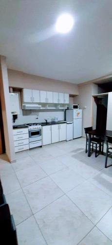 布兰卡港DEPTOS BAHIA的一间大厨房,配有白色的橱柜和一张桌子