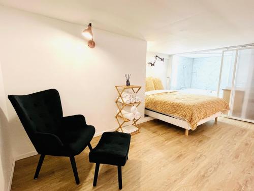 阿维尼翁Duplex-Ceiling height 1,9m-Free private parking-Netflix-Self check in !! Duplex climatisé-Hauteur sous plafond 1,9m-Parking privé gratuit-Netflix-Arrivée autonome !!的一间卧室配有一张床和一张黑椅