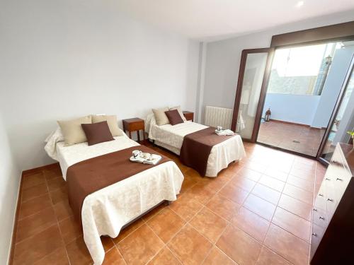丰东Casa de la Plaza的铺有瓷砖地板的客房内的两张床