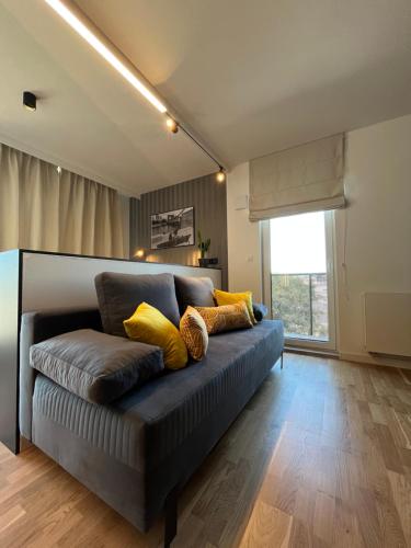 弗罗茨瓦夫Halo Apartments的客厅配有带黄色枕头的沙发