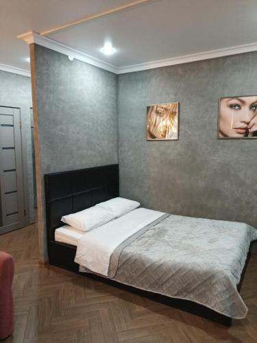 彼得罗巴甫洛夫斯克Квартира бизнес -класса в ста метрах от городского парка的卧室配有一张墙上有两张照片的床。
