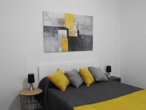 巴斯Precioso apartamento con sauna y terraza的一间卧室配有一张黄色和灰色枕头的床