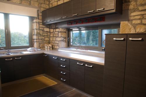 ElaíaEpirus Stone Suites的厨房配有深褐色橱柜和窗户。