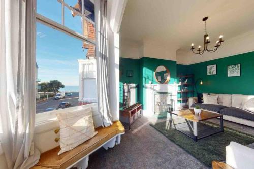 斯卡伯勒No.10 Seaside Apartment - 1st & 2nd Floor的客厅设有绿色的墙壁和大窗户