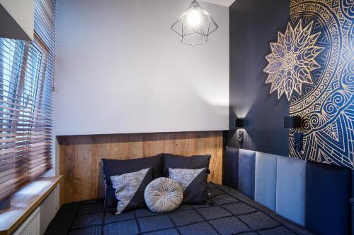 萨诺克Apartament z jacuzzi w centrum Sanoka的客房设有带枕头的沙发和墙壁。