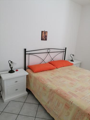 丽都玛里尼Villetta Lido Marini的一间卧室配有带橙色枕头的床