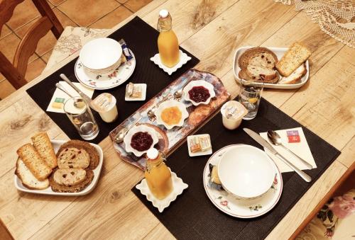 PluméliauTy Cosy, Chambre privée的餐桌,餐桌上放着食物、饮料和食物盘