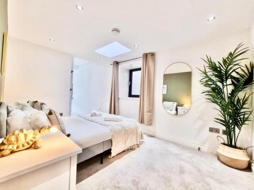 诺丁汉Luxurious Apartment in Nottingham Lace Market的白色卧室配有床和镜子