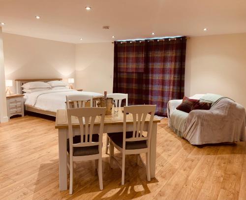 科尔切斯特Plumptons Farm Holiday Lodges的卧室配有一张床和一张桌子及椅子
