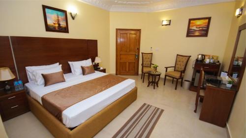 卡拉奇World Inn Karachi的酒店客房,配有一张床、一张桌子和椅子