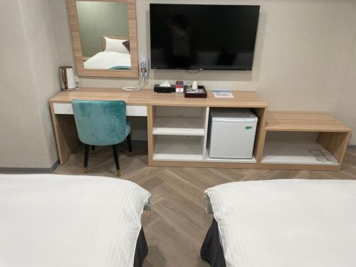 高雄慕晨旅店的客房设有书桌、电视和椅子