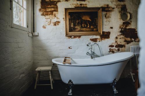 卡斯尔梅恩The Dairy的墙上有画作的房间,设有浴缸