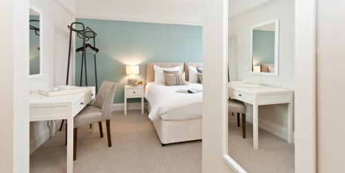 切达巴斯阿姆斯酒店的一间卧室配有一张床、一张书桌和一面镜子