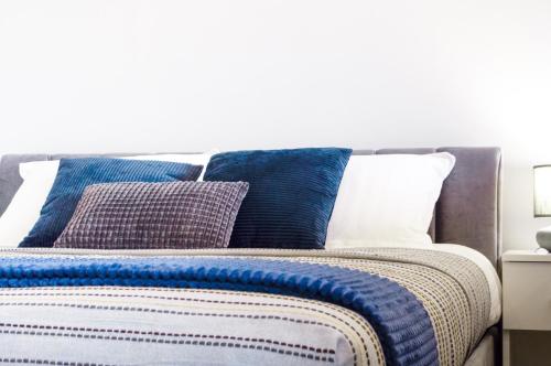 陶拉格Studijos tipo apartamentai Tauragėje的一张带蓝色和白色枕头的床