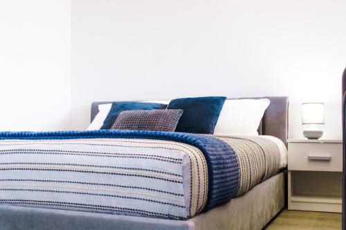 陶拉格Studijos tipo apartamentai Tauragėje的一张带蓝色和白色毯子及枕头的床