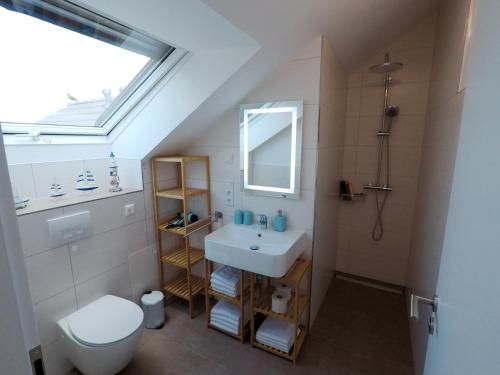 富尔达-Neubau- 30qm Dach-Apartment的一间带水槽和卫生间的浴室以及窗户。