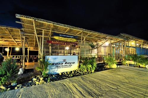 TibiaoKasa Raya Inn的一座建筑,在晚上前有标志