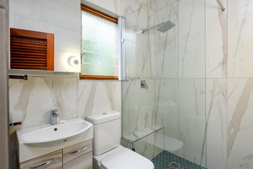 绍斯布鲁姆San Lameer Villa 3212 - 4 Bedroom Superior - 8 pax - San Lameer Rental Agency的浴室配有卫生间、盥洗盆和淋浴。