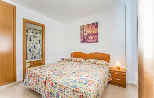 奥罗佩萨德尔马Apartamento de 3 dormitorios, 1º línea de playa en Marina d´Or的一间卧室配有一张带五颜六色棉被的床