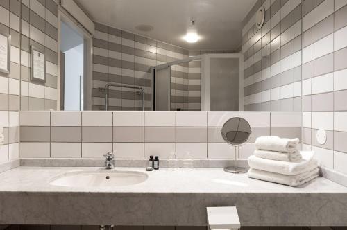 韦克舍瑞典精英酒店的浴室配有盥洗盆、镜子和毛巾