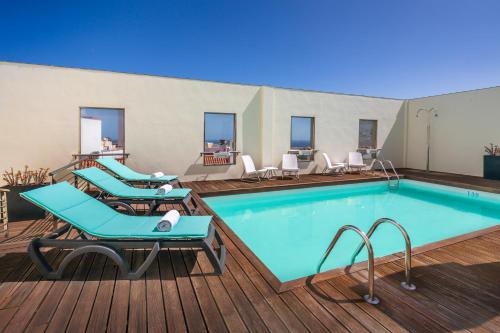 圣克鲁斯-德特内里费圣克鲁斯现代公寓的游泳池旁的甲板上设有躺椅
