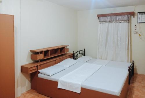 伊洛伊洛RedDoorz @ Plaza La Paz Iloilo City的一间卧室设有两张床、一个梳妆台和窗户。