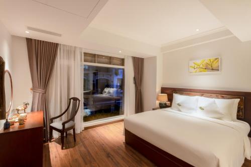 胡志明市Cochin Sang Hotel的一间卧室配有一张床、一张书桌和一个窗户。