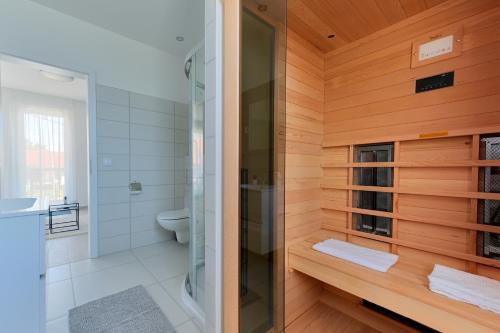 佐洛卡罗斯Villa Oliver Zalakaros的一间带玻璃淋浴和卫生间的浴室