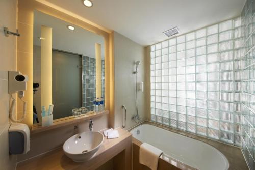 新郑郑州港区智选假日酒店的带浴缸、水槽和窗户的浴室