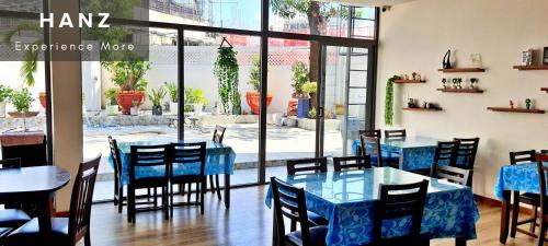 土龙木市HANZ Anh Duc Hotel的餐厅设有蓝色的桌椅和窗户。