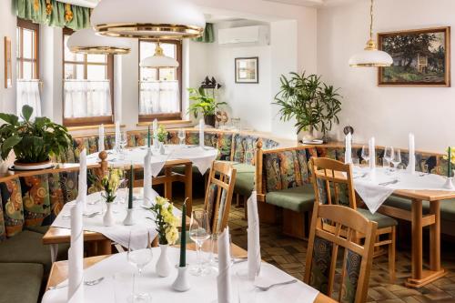 HeiligenbrunnGenussgasthof & Hotel beim Krutzler的餐厅设有白色的桌椅和窗户。