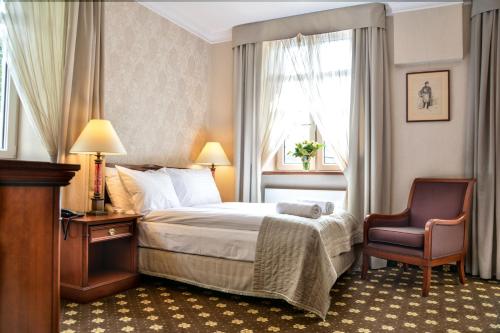 卡利什科莫达俱乐部酒店的配有一张床和一把椅子的酒店客房