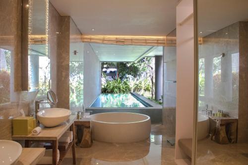 沙努尔玛雅沙努尔温泉度假酒店的浴室配有两个盥洗盆和浴缸。