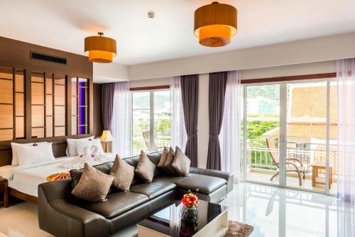 芭东海滩尼帕度假酒店 （政府卫生认证）的客厅配有床和沙发