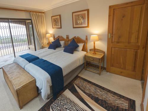 莫塞尔湾Golf & Tides的一间卧室配有一张带蓝色枕头的大床
