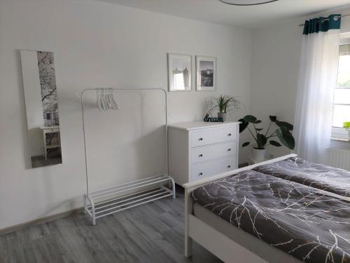 萨勒河畔哈雷Gemütliches, voll ausgestattetes Apartment的一间白色卧室,配有一张床和一个梳妆台