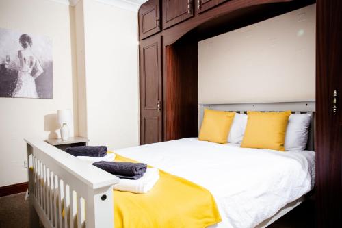 DouglasRigside House的一间卧室配有一张带黄色枕头的大床