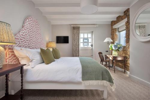 梅德伯纳内维尔阿姆斯酒店的卧室配有一张白色的大床和一张桌子