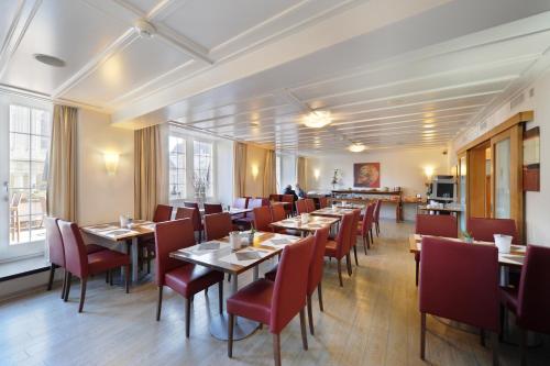 弗里堡德拉玫瑰酒店 的用餐室配有桌子和红色椅子