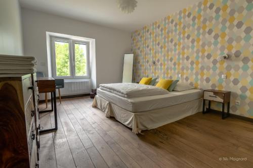 勒布罗伊斯Le Manoir, appartement Onyx的一间卧室配有一张带黄色枕头的床