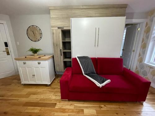 昂基Hôtel les quatre bonheurs的客厅里红色的沙发,配有白色的橱柜