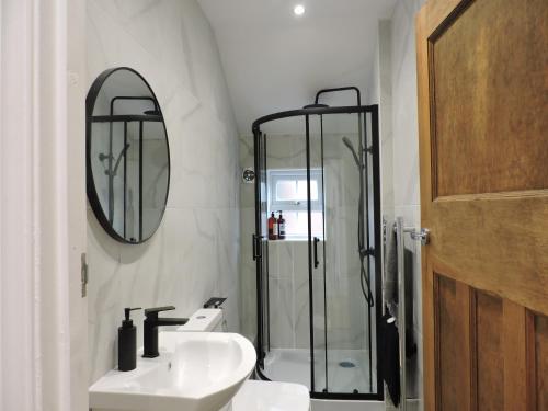 麦克尔斯菲尔德Bespoke Luxury Serviced Apartment的带淋浴、盥洗盆和镜子的浴室