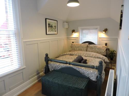 麦克尔斯菲尔德Bespoke Luxury Serviced Apartment的一间卧室配有一张床,其中配有长凳