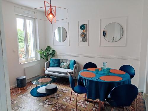 亚眠Irziana - Au jardin d'Henriville的客厅配有蓝色的桌子和椅子